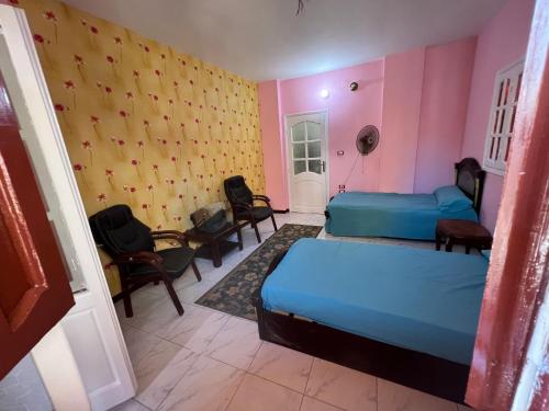Zimmer mit 2 Betten und Stühlen in der Unterkunft شقه حديثه في وسط المنصوره بالقرب من الجامعه ١٧٥ متر in Mansoura