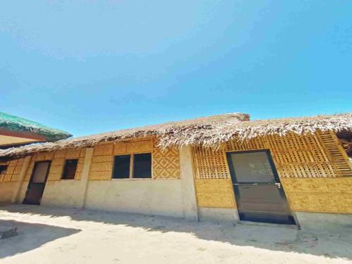 um edifício com telhado de palha e uma porta em Casa Vacanza -Dagat-Dagatan Beach Camp em Gubat