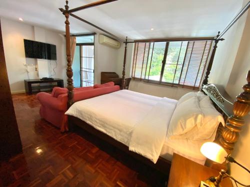 a bedroom with a bed and a red couch at Cafe ice resident in Yan Nawa