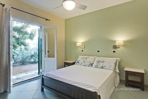 a bedroom with a bed and a sliding glass door at Rigò Apartments in Kyra Panagia