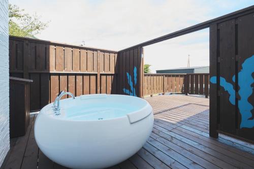 a white bath tub sitting on a deck at Little Seagull by SANA in Tateyama