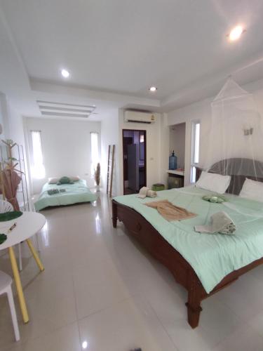 a bedroom with a large bed and a table at Luana Villas in Ban Mo Nae