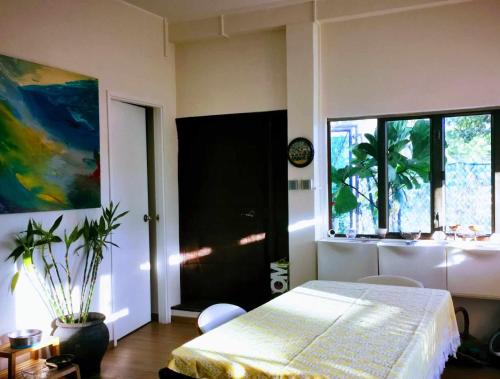 a bedroom with a bed and a large window at A private room in beachside bungalow for women only in Hong Kong