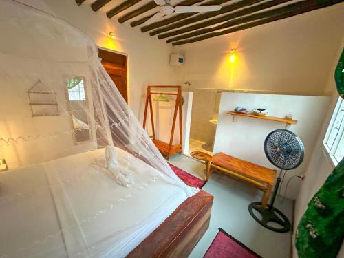 a room with a bed with a veil on it at The African Paradise Beach Hotel in Bwejuu