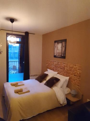 a bedroom with a large white bed with a brick wall at Stylish studio's Aspen Valley in Razlog