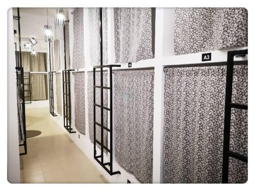 a row of doors with curtains on a wall at Sunset Homestay - Backpacker Hostel Self Checkin in Kuching