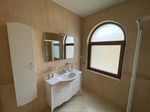 a bathroom with a sink and a mirror and a window at VILLAS GOLF in Balchik