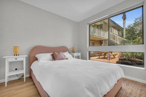 a bedroom with a large bed and a large window at Marine Court - Unit 6 in Merimbula