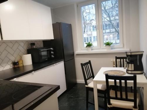 a kitchen with a table and chairs and a microwave at Apartament - Classic Olszowa in Włocławek