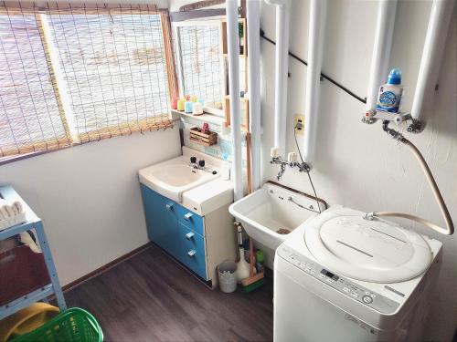 a small bathroom with a sink and a toilet at 愛犬と家族みんなでのんびり羽休めv古民家民泊OMOTENASHI LODGe 悠遊 in Nakafurano