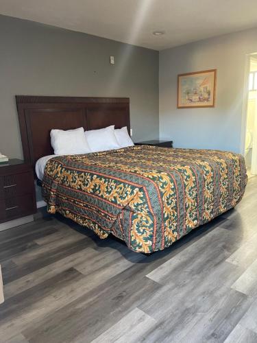 a bedroom with a large bed with a blanket on it at San Jacinto Inn in San Jacinto