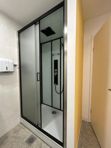 a glass shower in a room with a wall at Hostel Opera in Ljubljana