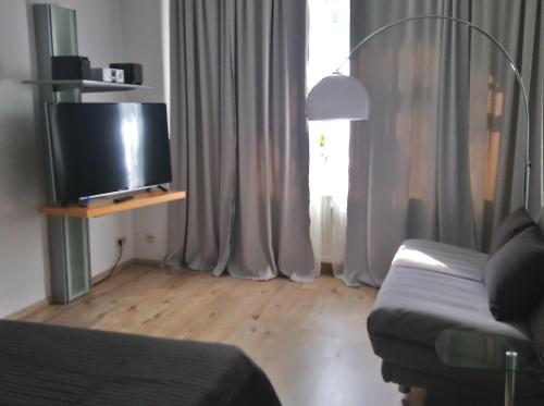 a living room with a couch and a flat screen tv at Gemütliche Ferienwohnung im Erdgeschoss- Jenaer Straße in Erfurt