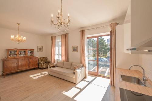 a living room with a couch and a chandelier at Villa Musik - historical apartments, Baden in Baden