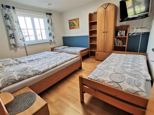 a bedroom with two beds and a tv at Ferienwohnung Fuchs 