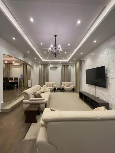 uma sala de estar com sofás e uma televisão de ecrã plano em Fedora Luxury Villa in Lekki Phase 1 em Lekki