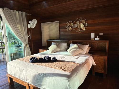 a bedroom with a bed with shoes on it at บ้านสวนปิยนันท์ (Baansuan Piyanan) in Ko Yao Noi