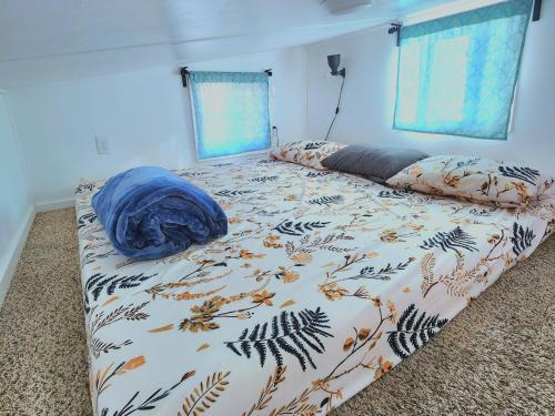 a bedroom with a bed with a blanket on it at Tiny Home Hot Tub in Colorado City