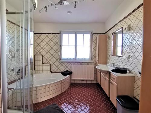 a bathroom with a tub and a sink at Ferienwohnung Fuchs 