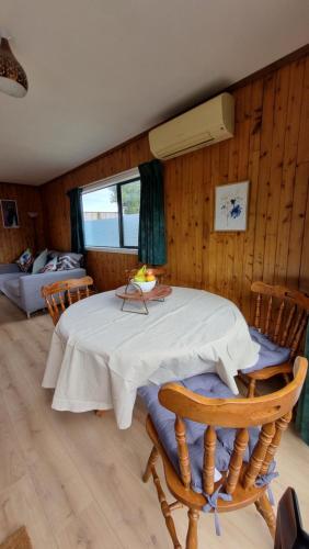 a room with a table and chairs and a bedroom at Kereru Cottage in Whakamarama