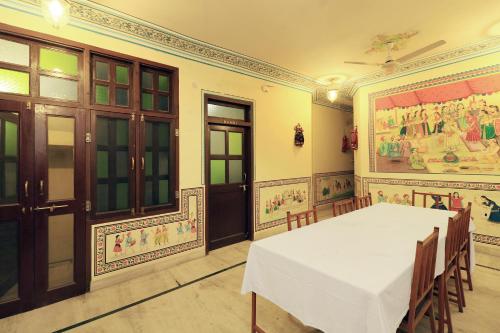 a dining room with a table and a painting on the wall at Flagship Hotel Baba Haveli in Jaipur