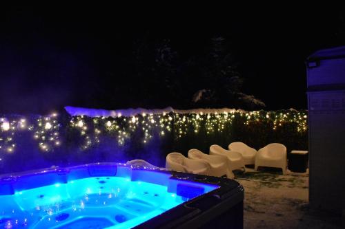 a hot tub in a yard with chairs and lights at Serenity in Pribylina