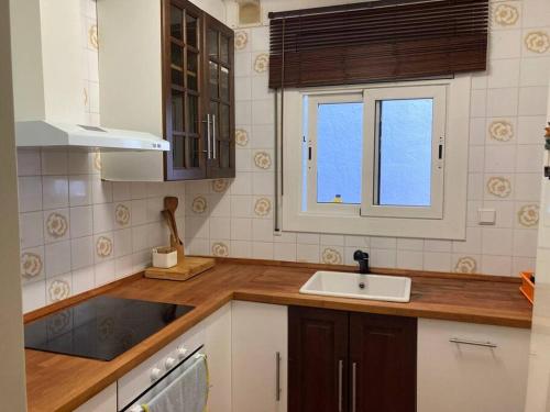 eine Küche mit einem Waschbecken und einem Fenster in der Unterkunft Para amantes de espacios amplios, sol y relax in Argentona