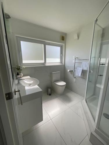 e bagno con servizi igienici, lavandino e doccia. di Central Howick Uxbridge Apartments ad Auckland