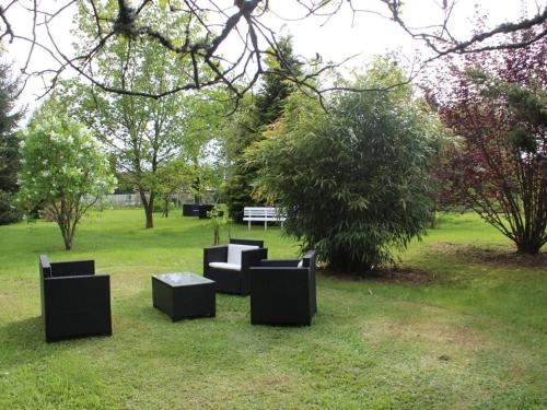 un groupe de bancs noirs assis dans l'herbe dans l'établissement Domaine du parc, à Grandvillers