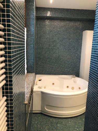 a bath tub in a bathroom with blue tiles at IL SALICE in Novara