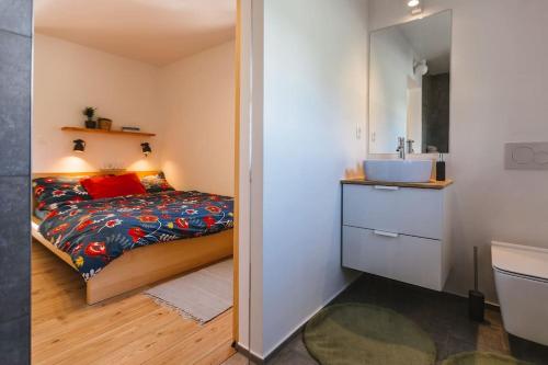 1 dormitorio con 1 cama y baño con lavamanos en Pr'Kovač 2 /Perfect stay for 2, en Bohinjska Bela