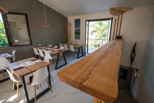 a restaurant with tables and chairs and a large wooden counter at ProKite Alby Rondina - RESORT - in Birgi Vecchi