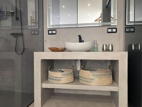 a bathroom with a sink and a counter with baskets at private loft-sea views-Jacuzzi in La Asomada
