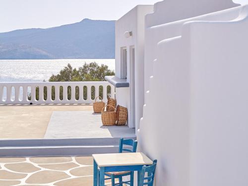 a balcony with chairs and a view of the water at Mykonos Lolita, A Grecotel Resort to Live in Agios Sostis Mykonos