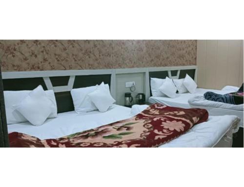 2 Betten in einem Zimmer mit weißen Kissen in der Unterkunft Hotel Shree Badri Valley, Badrinath in Badrīnāth