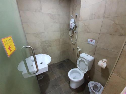 a bathroom with a toilet and a shower stall at Bunny Homestay 408 @ Roxy Apartment Kuching in Kuching