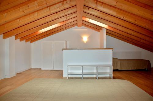 Habitación grande con cama blanca y techo de madera. en Nice three bedroom apartment close to the sea, en Bibione