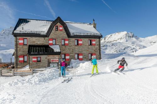a group of people skiing in front of a building at Ferienwohnung Sabine in Flattach