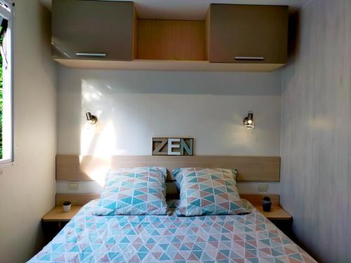 une chambre avec un lit avec des oreillers bleus dans l'établissement Le TropeZen Confort Plus TV WIFI VOD Salle de Sport !, à Gassin