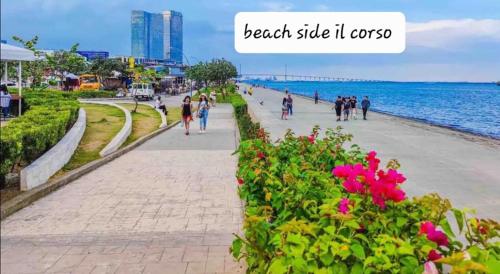 people walking on a sidewalk next to the beach at Two-Bedroom at San Remo Oasis in Cebu City
