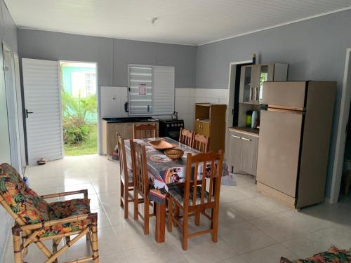 uma cozinha com uma mesa e cadeiras e um frigorífico em Casa de Praia em Tramandaí