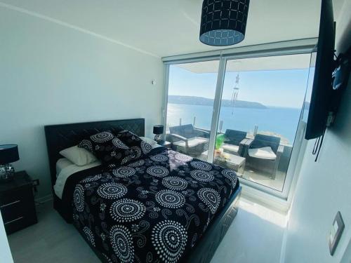 a bedroom with a bed and a view of the ocean at Departamento frente a la playa full amoblado in Coquimbo