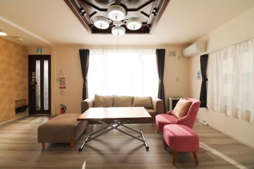 a living room with a couch and a table and chairs at HDO Hachiken Villa in Sapporo