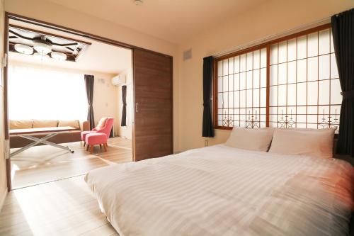 a bedroom with a large bed with a large window at HDO Hachiken Villa in Sapporo