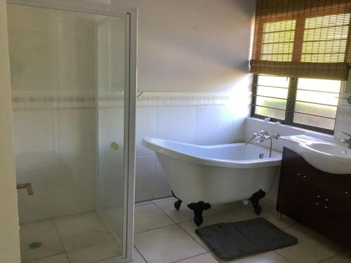 a bathroom with a tub and a shower and a sink at The Bell's in the Berg in Underberg