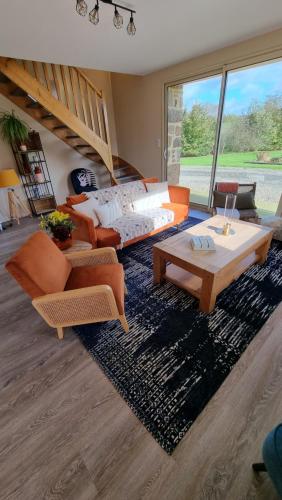 uma sala de estar com um sofá e uma mesa em Mon Pré Vert em Saint-Ellier-du-Maine