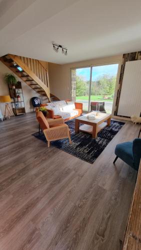 uma grande sala de estar com um sofá e uma mesa em Mon Pré Vert em Saint-Ellier-du-Maine