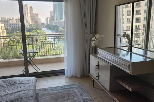 una camera con cassettiera e ampia finestra di Lake View The Greens & Views a Dubai
