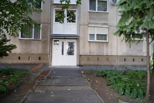 a building with a white door and a bench in front at Comfort 28 B in Miskolc