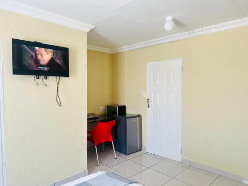 a room with a desk and a tv on the wall at MBT Guesthouses in Ga-Mothiba